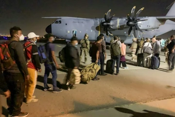 Des Français et des Afghans attendent pour embarquer à bord d'un avion de transport militaire français le 17 août 2021 à l'aéroport de Kaboul