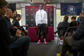 Le marathonien kényan Eliud Kipchoge (c) pose pour les photographes, le 10 octobre 2019 à Vienne