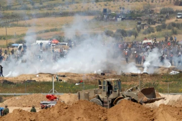 Les soldats israéliens tirent des gaz lacrymogènes sur des manifestants palestiniens le long de la barrière de sécurité séparant la bande de Gaza d'Israël, le 6 avril 2018 