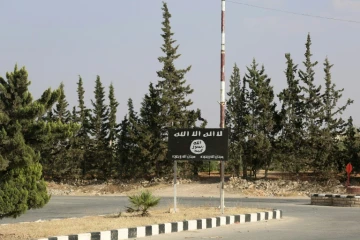 Un drapeau du groupe Etat islamique sur la route qui mène à Minbej, dans le nord de la Syrie, le 23 juin 2016