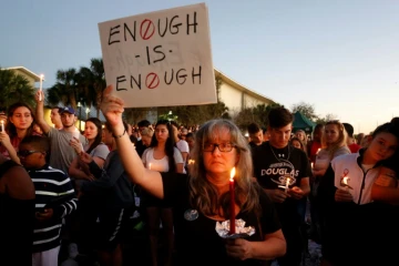 Une manifestante brandit une pancarte clamant "Assez c'est assez !" lors d'une veillée pour les victimes de la fusillade du lycée à Parkland qui a coûté la vie à 17 personnes 