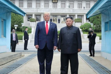 Photo fournie le 1er juillet 2019 par l'agence nord-coréenne Kcna du dirigeant nord-coréen Kim Jong Un (d) et le président américain Donald Trump se tenant au nord de la ligne de démarcation entre les deux Corées,  le 30 juin 2019 à Panmunjom