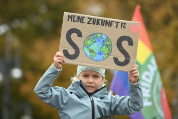 Une petite fille participant à la manifestation pour le climat à Berlin tient une pancart où est inscrit "Mon avenir ?! SOS", le 22 octobre 2021