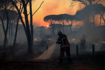 Un pompier français utilise une lance d'incendie lors d'un feu de forêt dans le département du Var, dans le sud de la France, le 17 août 2021