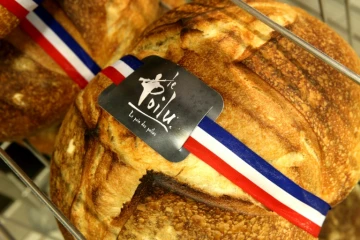 Une miche au levain sertie d'un ruban tricolore: le "pain des Poilus", réplique fidèle de celui distribué aux soldats français pendant la Première Guerre mondiale, le 6 avril 2018 dans une boulangerie de Sedan (Grand Est)