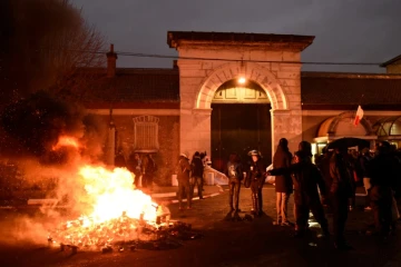 Des palettes de bois brûlent devant l'entrée de la prison de Fresnes bloquée par des surveillants, le 16 janvier 2018 