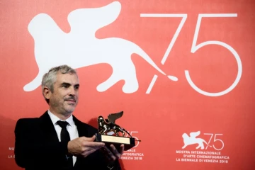 La réalisateur Alfonso Cuaron pose avec le Lion d'Or du meilleur film qu'il a remporté pour "Roma" au Festival de Venise le 8 septembre 2018