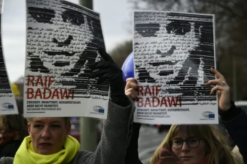 Des membres de l'ONG Amnesty International brandissent des portraits du blogueur saoudien Raef Badawi lors d'une manifestation devant l'ambassade d'Arabie saoudite à Berlin, le 8 janvier 2016.