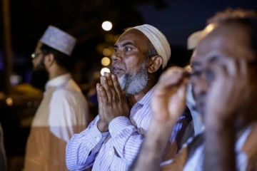 Des hommes devant une mosquée dans le quartier d'Ozone Park, à New York, où un imam et son assistant ont été abattus, le 13 août 2016
