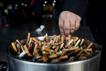 Un homme écrase une cigarette dans un cendrier dans une gare à Shanghai, le 28 février 2017 en Chine
