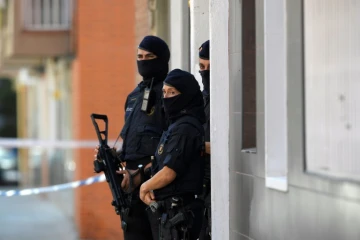 La police catalane monte la garde près d'un immmeuble où vivait un homme qui a attaqué un commissariat à Cornella près de Barcelone, le 20 août 2018