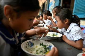 Des écoliers prennent un petit-déjeuner avant d'entrer en classe, le 8 juillet 2022 dans la province de Siem Reap, au Cambodge
