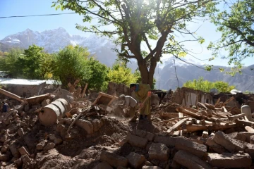 Des survivants au milieu des ruines le 29 octobre 2015 dans le village de Charun Avir au Pakistan