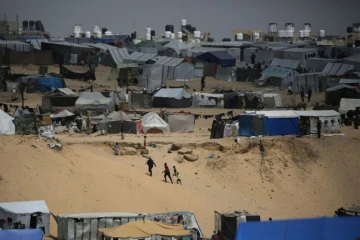 Des Palestiniens marchent dans un camp de personnes déplacées à Rafah, dans le sud de la bande de Gaza, près de la frontière avec l'Egypte, le 28 avril 2024