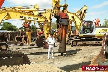 Élise Hermann devant ses engins de terrassement