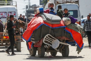 Des enfants palestiniens assis sur leurs affaires, rassemblées dans une charrette à cheval, à Nousseirat (centre de la bande de Gaza), le 12 avril 2024