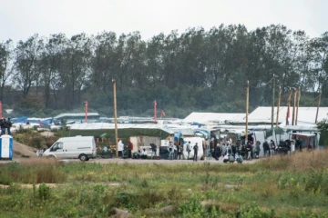 Des migrants à l'entrée de la "Jungle" de Calais, le 21 octobre 2016