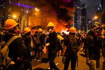 Des manifestants masqués occupent une barricade sur une grande artère de Hong Kong