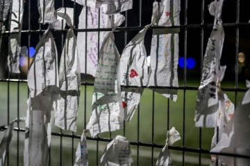 Des messages sont accrochés à la clôture du stade de football de Lutry en Suisse, le 8 janvier 2026, en mémoire des victimes de l'incendie mortel du réveillon du Nouvel An à Crans-Montana