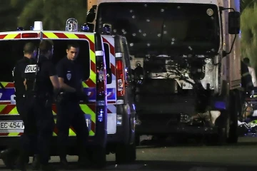 Des policiers près du camion criblé de balles qui a intentionnellement fauché la foule sur la Promenade des Anglais à Nice, le 14 juillet 2016