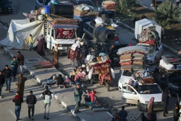 Des déplacés palestiniens  attendent près du passage de Netzarim, qui coupe la bande de Gaza en deux, avant de pouvoir regagner le nord du territoire, le 26 janvier 2025
