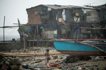 Un enfant au milieu d'une maison endommagée par le thyphon Nock-Ten le 26 décembre 2016 à Manille