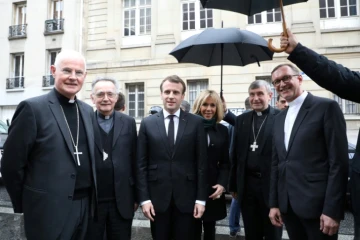 Emmanuel Macron (3eG) le 9 avril 2018 à Paris, avec notamment sa femme Brigitte Macron (3eD), l'archevêque de Montpellier Mgr Pierre-Marie Carreé (G) l'archevêque de Marseille et Pdt de la Conférence des évêques de France, Mgr Georges Pontier (2eG)