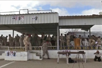 Une capture d'image d'une vidéo obtenue par l'AFPTV montrant des soldats yéménites et des reporters au moment de l'explosion d'un drone au dessus d'une parade militaire à al-Anad dans le sud du Yémen qui a fait au moins six morts, le 10 janvier 2019