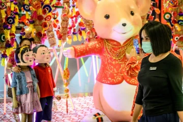 Une femme porte un masque de protection contre le nouveau coronavirus dans un magasin décoré pour le Nouvel An chinois à Bangkok le 24 janvier 2020