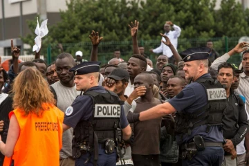 Une chargée de mission de la Préfecture du Nord-Pas-de-Calais sélectionne les migrants qui pourront monter à bord d'un bus à destination d'un Centre d'accueil et d'orientation, le 13 septembre 2016 à Calais