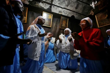 Des pèlerins chéritiens prient dans la grotte de la basilique de la Nativité, à Bethléem, en Cisjordanie occupée, le 24 décembre 2019