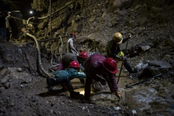 Des mineurs fouillent la terre dans une mine de rubis à Mogok, au nord de Mandalay, le 24 novembre 2016