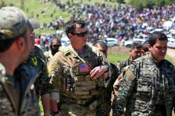 Un officier américain, de la coalition dirigée par les États-Unis, parle avec des combattants des unités de protection du peuple kurde (YPG) au nord-est de la ville kurde syrienne de Derik, connue sous le nom d'al-Malikiyah, le 25 avril, 2017