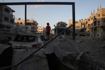 Un jeune Palestinien se tient près de gravats d'un bâtiment détruit par un bombardement israélien dans le camp de réfugiés de Nousseirat, dans le centre de la bande de Gaza, le 22 août 2024, sur fond de guerre entre Israël et le mouvement islamiste Hamas