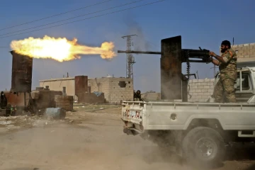 Un combattant syrien proturc tire à la mitrailleuse lors de combats dans la ville de Ras al-Aïn dans le nord de la Syrie, le 13 octobre 2019 