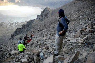 Des randonneurs et leur guide s'approchent du cratère volcanique d'Al Wahbah, à quelque 360 km au nord-est de Jeddah, en Arabie saoudite, le 17 novembre 2017