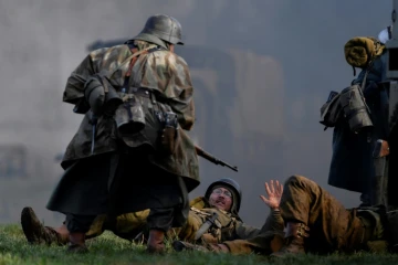 Un acteur en uniforme allemand de la Seconde Guerre mondiale lors d'une scène de capture de soldats américains durant une reconstitution de la bataille des Ardennes, à Hardigny (Belgique) le 15 décembre 2019