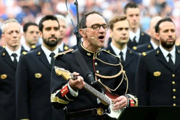 Jean-Michel Mekil, un gendarme de la Garde républicaine, chante et joue la chanson Don't Look Back in Anger d'Oasis au Stade de France à la mémoire des victimes des attentats en Grande-Bretagne, avant le match France-Angleterre le 13 juin 2017