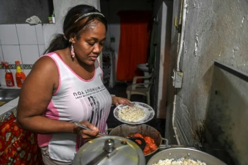 La Colombienne Elizabeth Mosquera, qui a perdu son emploi, prépar le dîner dans sa cuisine, le 7 décembre 2020 à Medellin, en Colombie