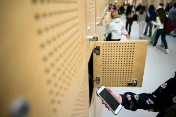 Une élève dépose son téléphone portable dans un casier après l'avoir éteint, au collège Auguste Brizeux à Lorient, le 5 septembre 2024 dans le Morbihan