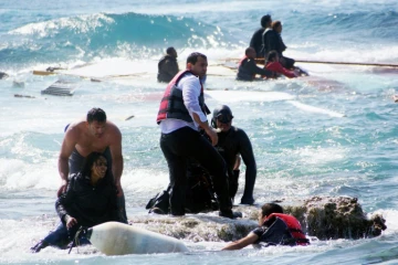 Des migrants secourus par des habitants après le naufrage de leur embarcation le 20 avril 2015 au large de Rhodes en Grèce