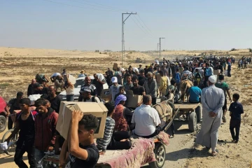 Des Palestiniens déplacés marchent le long d'une route pour recevoir des colis d'aide humanitaire d'un centre d'aide soutenu par les États-Unis à Rafah, dans le sud de la bande de Gaza, le 5 juin 2025