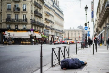 Un SDF dort le 16 janvier 2017 sur le trottoir à Paris où une vague de froid est attendue dans les prochains jours