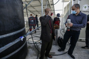 Un ingénieur boit de l'eau produite par un appareil retirant l'humidité de l'air, à Khan Younès (Gaza) le 16 novembre 2020