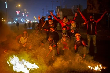 Des Irakiens manifestent près de pneus enflammés pour barrer une route à Bassora, dans le sud de l'Irak, le 24 décembre 2019