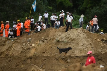 Des secouristes, pompiers et habitants sur les lieux d'un glissement de terrain à Santa Catarina Pinula, à 15 km à l'est de Guatemala, le 2 octobre 2015