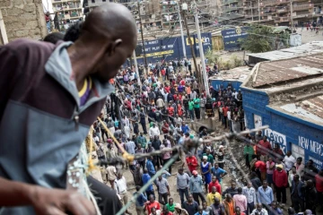 Des kényans se rassemblent autour de la maison d'une enfant tuée par balle sur le balcon de sa maison,  le 12 août 2017, dans les bidonvilles de Mathare à Nairobi