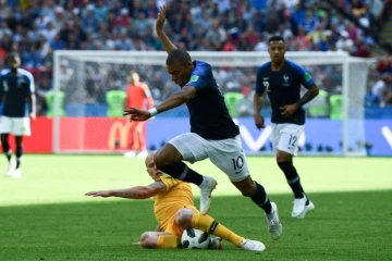 L'attaquant français Kylian Mbappé taclé par l'Australien Aaron Mooy lors du Mondial le 16 juin 2018 à Kazan