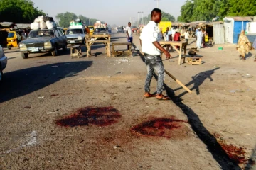Un Nigérian s'éloigne de la scène d'une attaque suicide qui a fait 13 morts le 23 octobre 2017 à Maiduguri, dans le nord-est du Nigeria