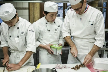 Un chef français (d) donne un cours de cuisine à des étudiants japonais à l'école Tsuji à Liergues, dans le Rhône, le 3 décembre 2015